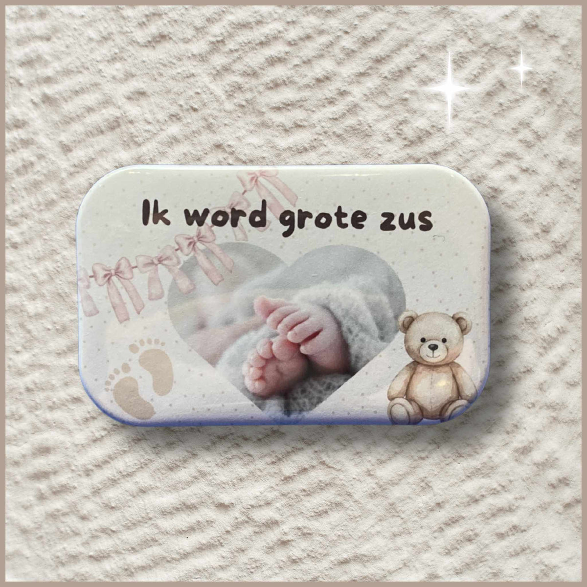 Rechthoekige gepersonaliseerde foto button met de tekst 'Ik word grote zus', babyvoetjes en een knuffelbeer.