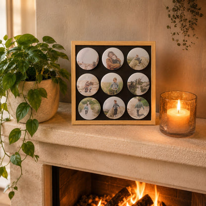 Sfeervolle schouw met een brandende haard en een magneetbord met houten lijst vol met negen ronde fotomagneten van een gezin.