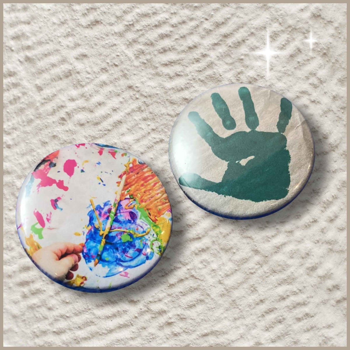 Twee ronde gepersonaliseerde foto buttons van 38 mm met een afdruk van een kinderhandje en een schilderij van een kind.