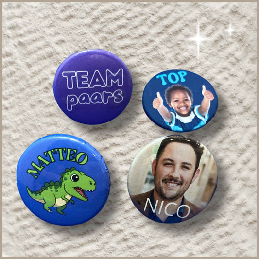 Vier ronde gepersonaliseerde foto buttons van 38 mm: twee naamtags, een button met de tekst 'Top' en een button met de tekst 'Team Paars'.
