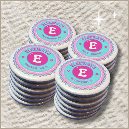 Set van 25 ronde magneten van 59 mm met het Elseways-logo, verdeeld over vier stapeltjes.